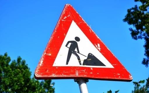 Baustellenschild vor blauem Himmel