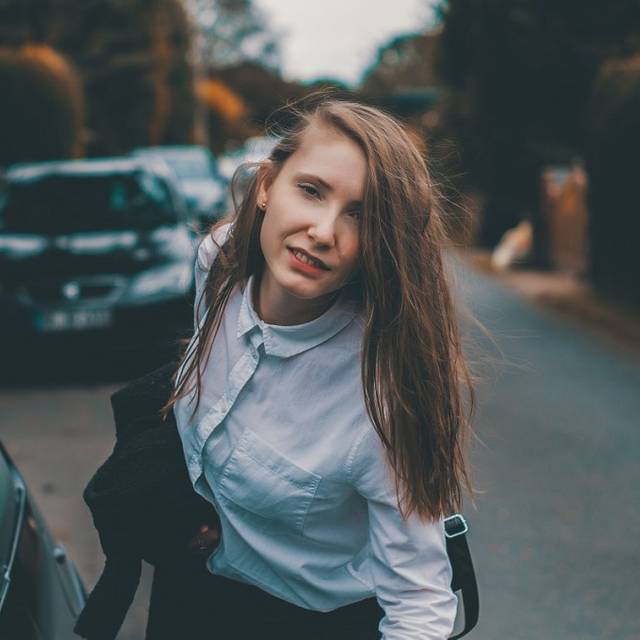 Junge Frau im Business-Dress neben einem Auto
