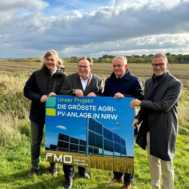 Verantwortliche mit Schild der Agri-PV-Anlage