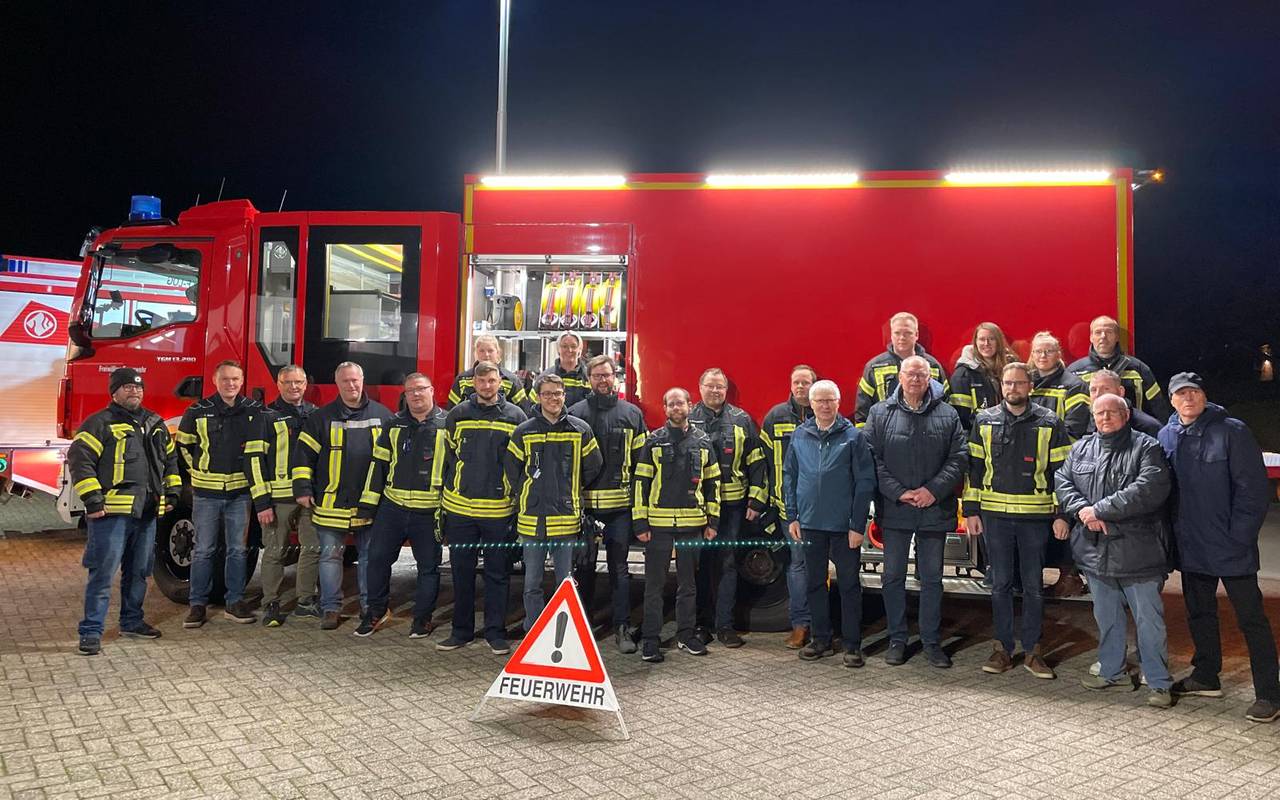 Alle Feuerwehrleute der Feuerwehr Leeden versammelt vor ihrem Feuerwehrauto