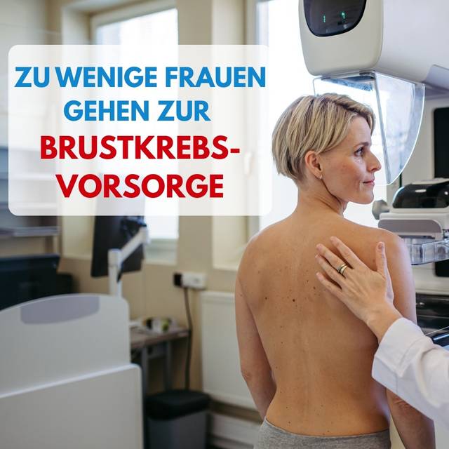 Eine Ärztin und eine Frau stehen nebeneinander. Die Frau steht vor einer Maschine zur Brustkrebsvorsorge.