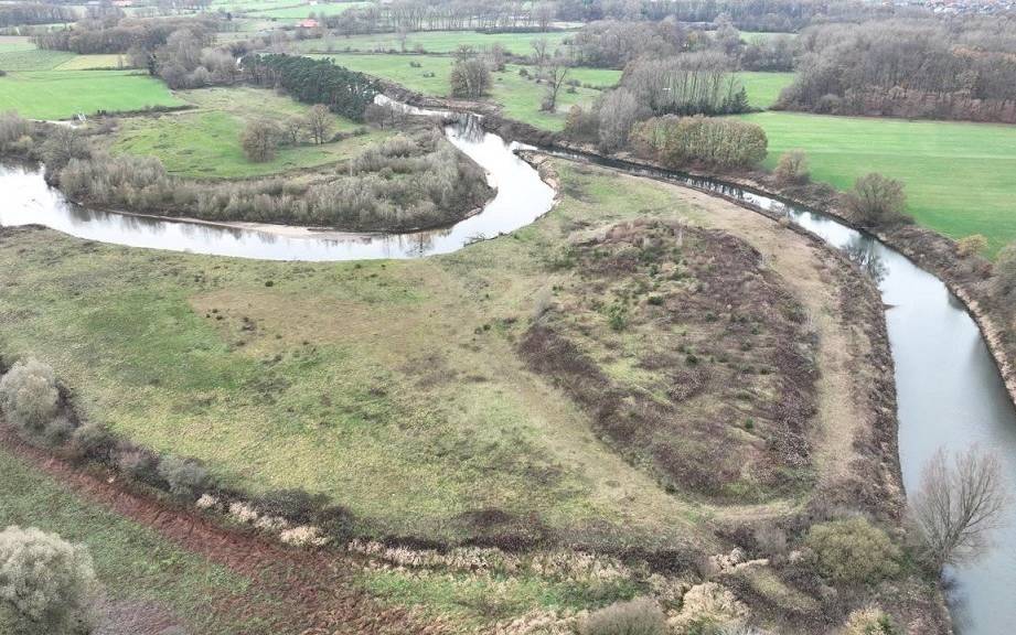 Drohnenaufnahme eines Emsabschnitts. Die Ems mäandert in diesem Bereich stark. Teilweise sind Uferböschungen zu erkennen, teilweise kleine Sandstrände. Zwischen den Emsschleifen unberührte Natur, weiter außen die typische münsterländische Parklandschaft mit Feldern, Wallhecken und Waldstücken.