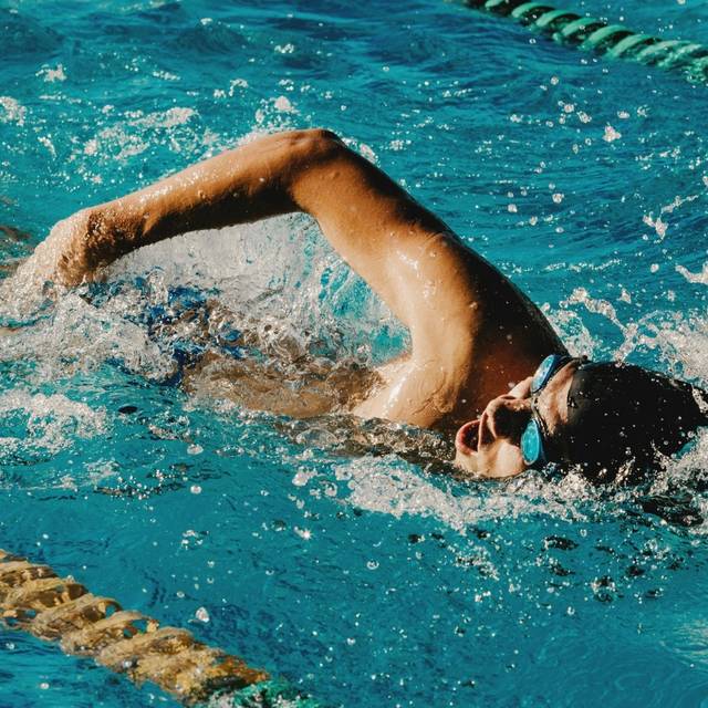 Ein Mann schwimmt durch ein Becken in einem Schwimmbad.