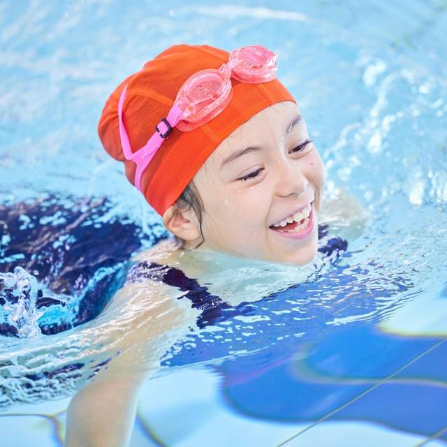 Ein Mädchen schwimmt in einem Schwimmbad.