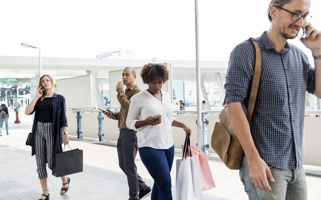 Junge Menschen in einem öffentlichen Bereich - alle mit ihren Smartphones beschäftigt.
