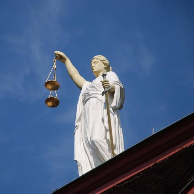 Eine Statue der Justitia mit Waage auf einem Dach