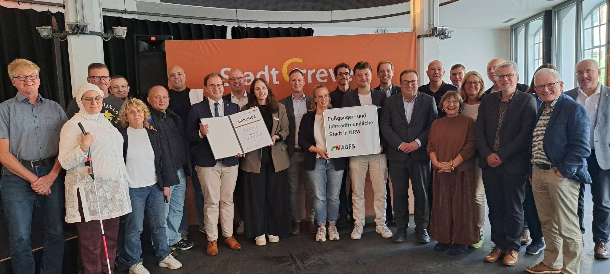 Grevens Bürgermeister Dietrich Aden und NRW-Verkehrsminister Krischer auf einem Gruppenfoto.