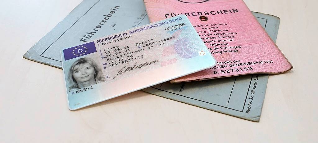 Führerscheine liegen auf einem Holztisch.