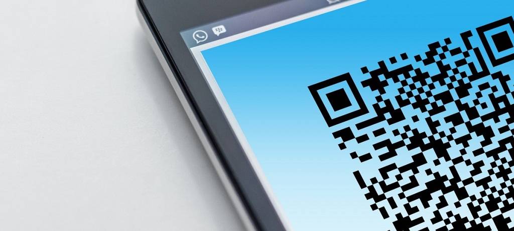 Ein QR-Code auf einem Smartphone, das nur teilweise ins Bild hineinragt
