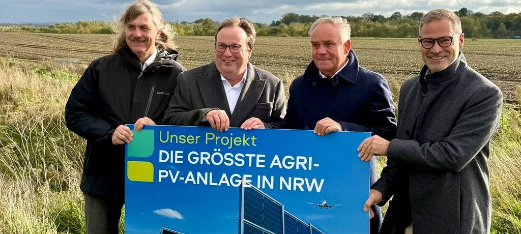 Verantwortliche mit Schild der Agri-PV-Anlage