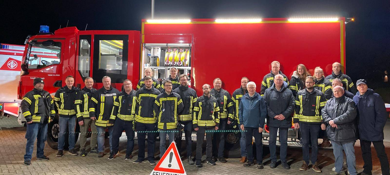 Alle Feuerwehrleute der Feuerwehr Leeden versammelt vor ihrem Feuerwehrauto