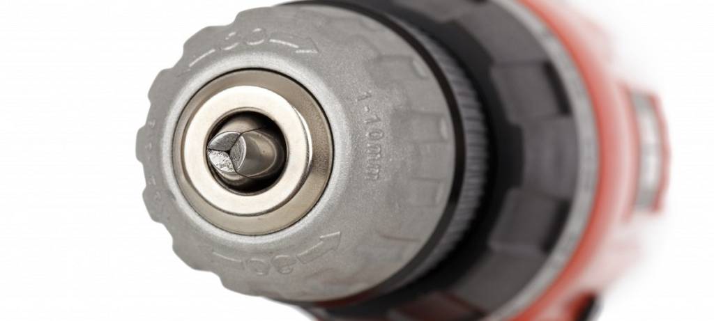 Detailansicht einer roten Bohrmaschine von vorne mit blick auf das Bohrfutter. Alles andere ist unscharf.