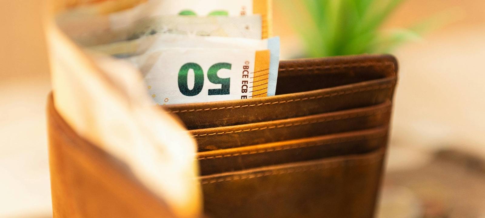 Gelscheine ragen aus einem Portemonnaie.