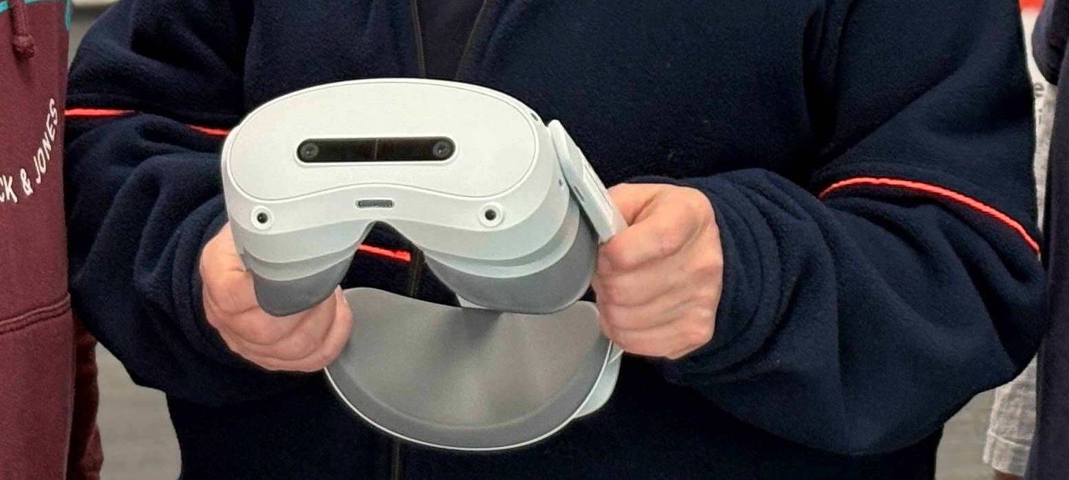 Vertretende der Malteser in Münster stehen zusammen und halten eine VR-Brille in der Hand.