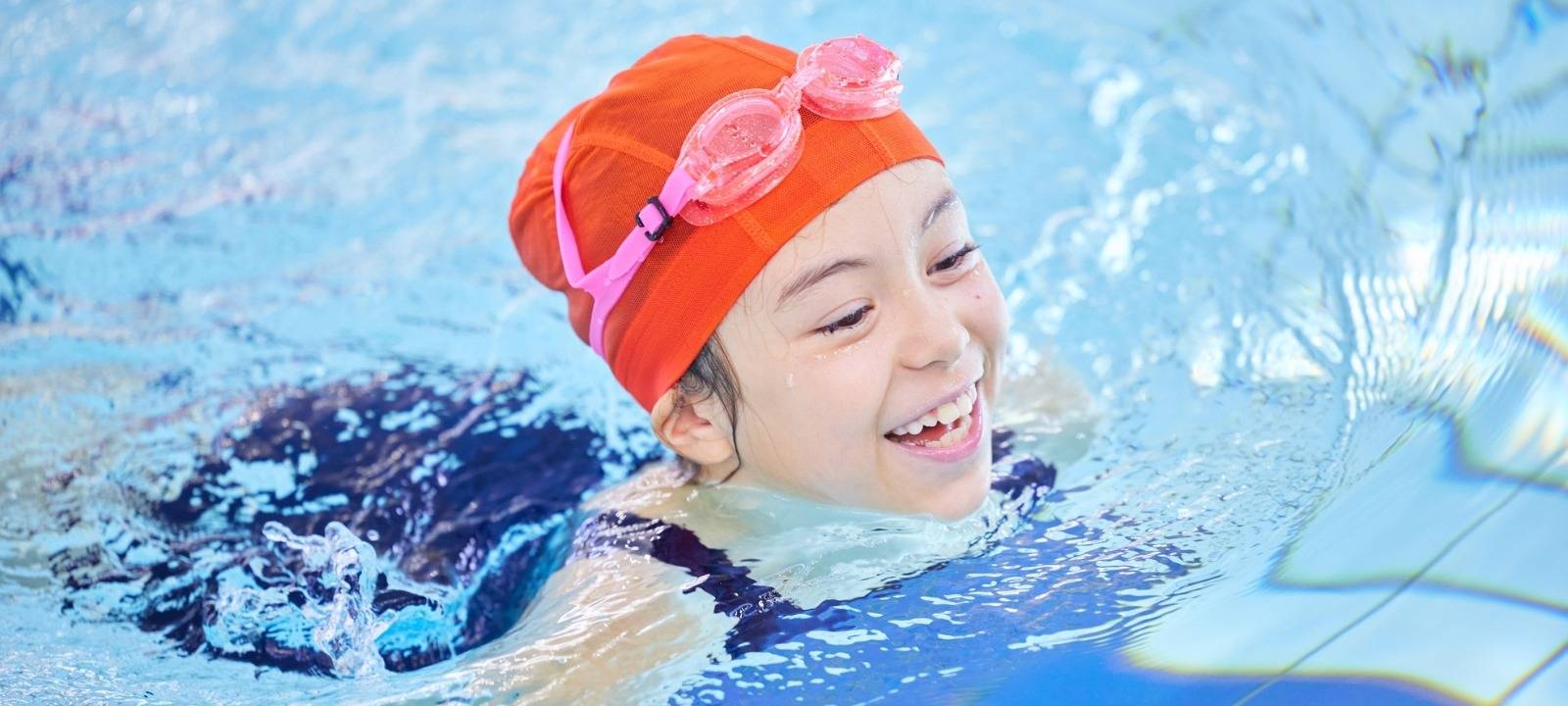 Ein Mädchen schwimmt in einem Schwimmbad.