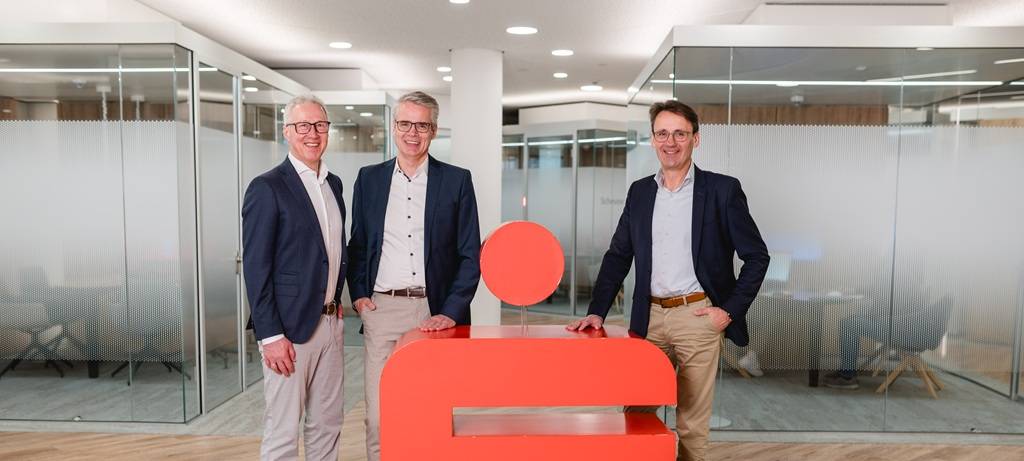 Der dreiköpfige Vorstand der Kreissparkasse Steinfurt hinter einem großen roten 3D-Sparkassenlogo