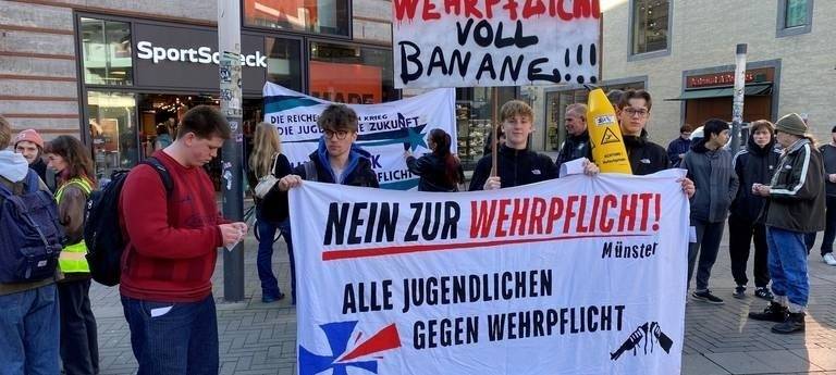 Schülerinnen und Schüler beim Schulstreik mit Transparenten wie "Wehrpflicht voll Banane" und "Nein zur Wehrpflicht"