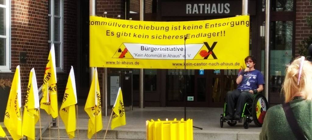 Demo gegen geplante Castor-Transporte vor dem Ahauser Rathaus mit gelbem Transparent und gelben Fässern mit Atom-Symbol
