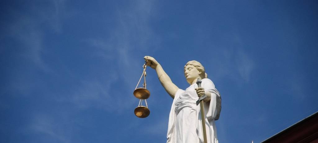 Eine Statue der Justitia mit Waage auf einem Dach