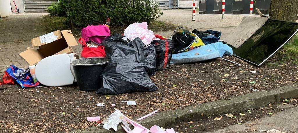 Bild einer illegalen Müllkippe mitten in der Wohnbebauung mit Müllsäcken, Toilettensitz, Bau-Eimer und Stücken von Wärmedämmung - schon auseinander gepflückt bis auf die Straße.