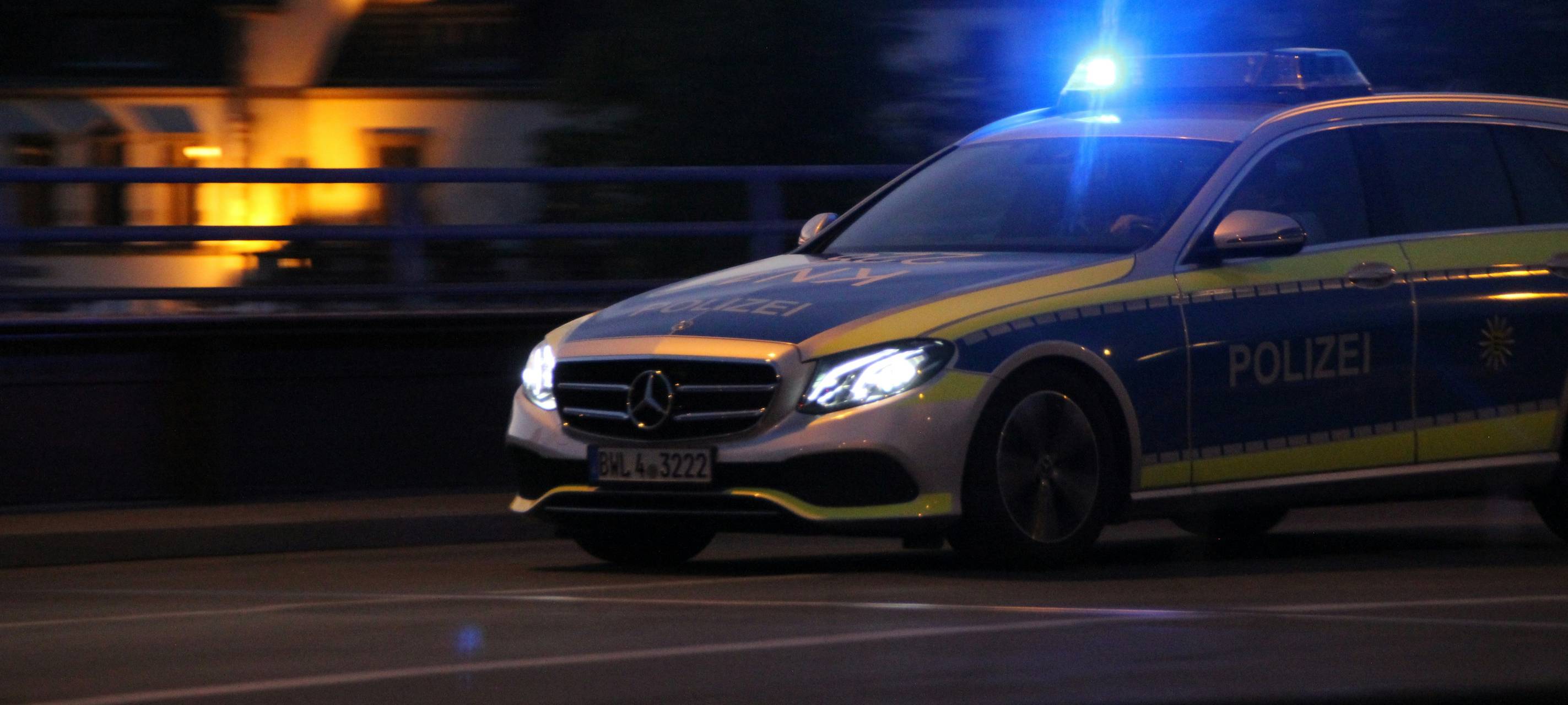 Ein Polizeiauto fährt über eine Straße.