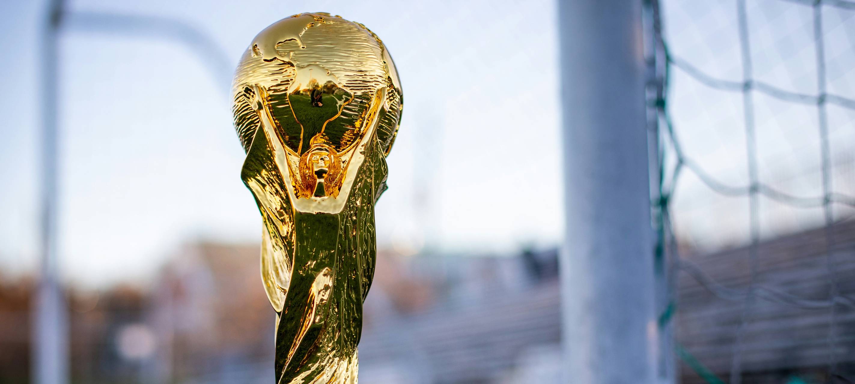 Der Pokal der Fußball WM steht vor einem Tor.