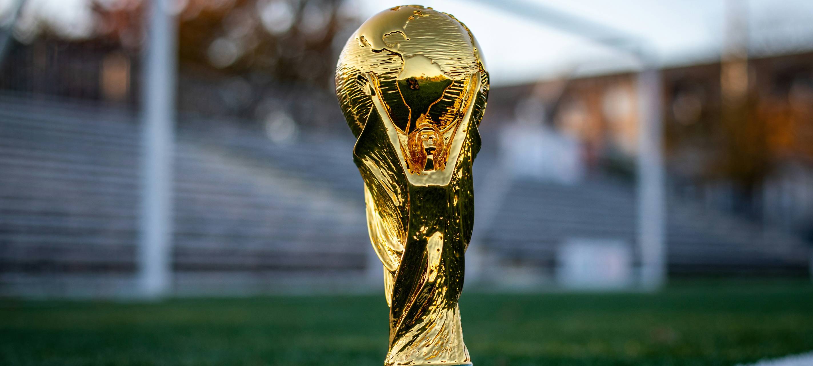 Der Fußball-WM-Pokal steht vor einem Tor.