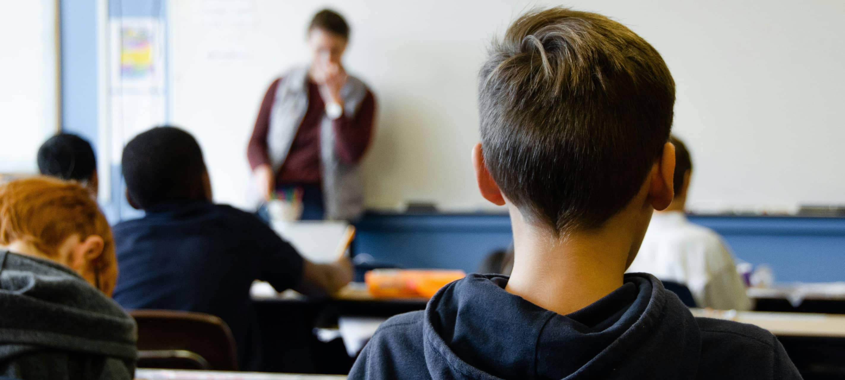 Ein Schüler sitzt in einem Klassenraum.