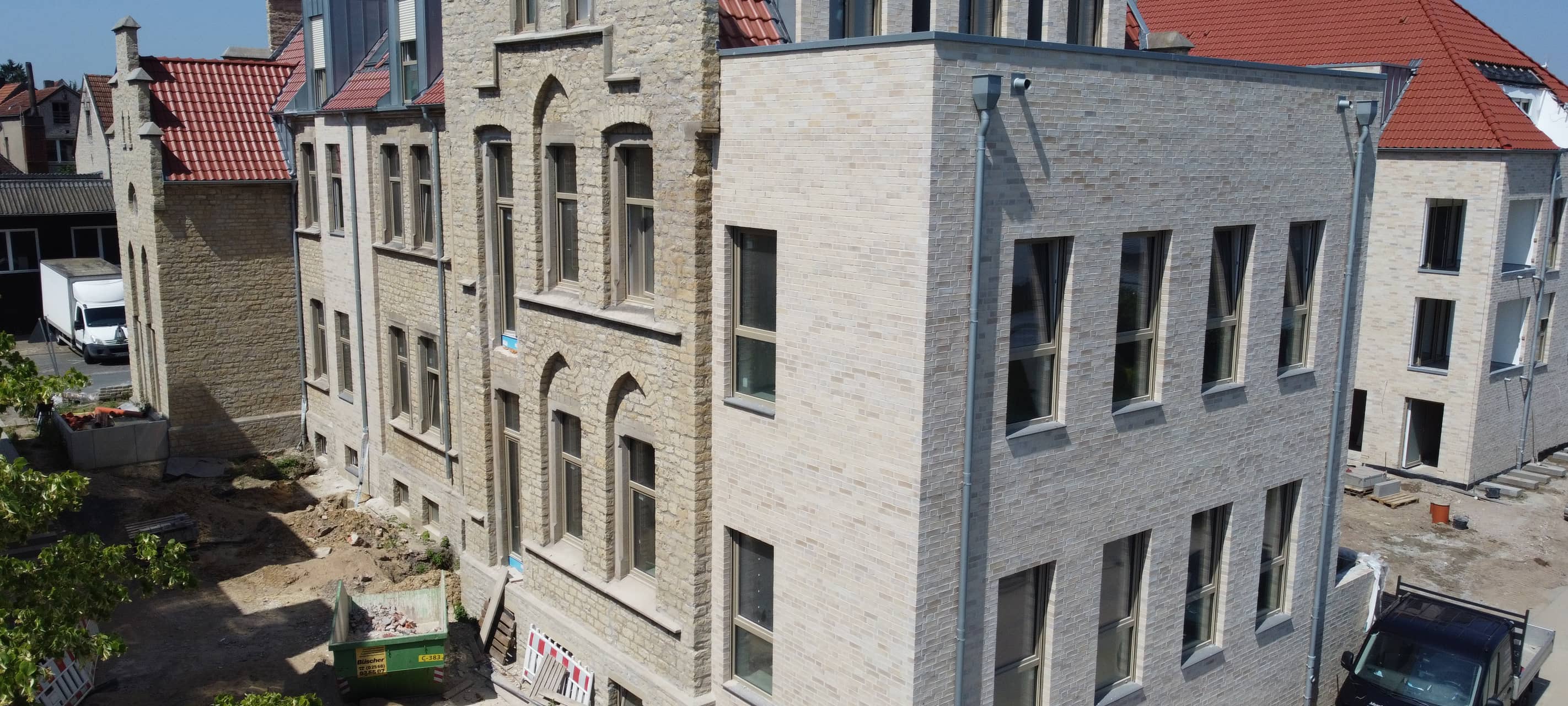 Eine Mehrfamilienhaus, das historische Fassadenteile und Neubau miteinander verbindet