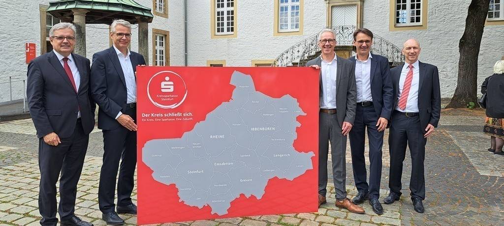 Eine Wärmepumpe an einer Hauswand montiert. Drumherum teils blühende Rosen.