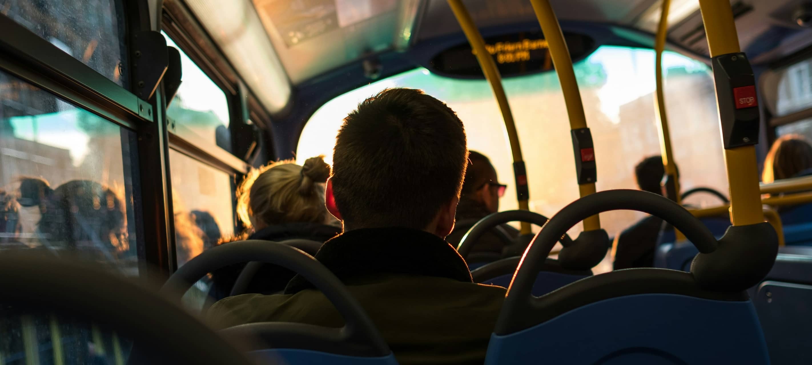 Ein Mann sitzt in einem vollen Bus.