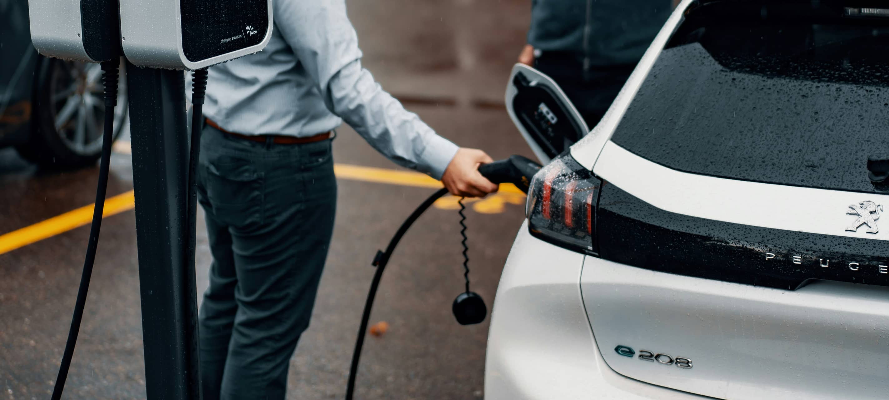 Ein Mann lädt sein E-Auto.